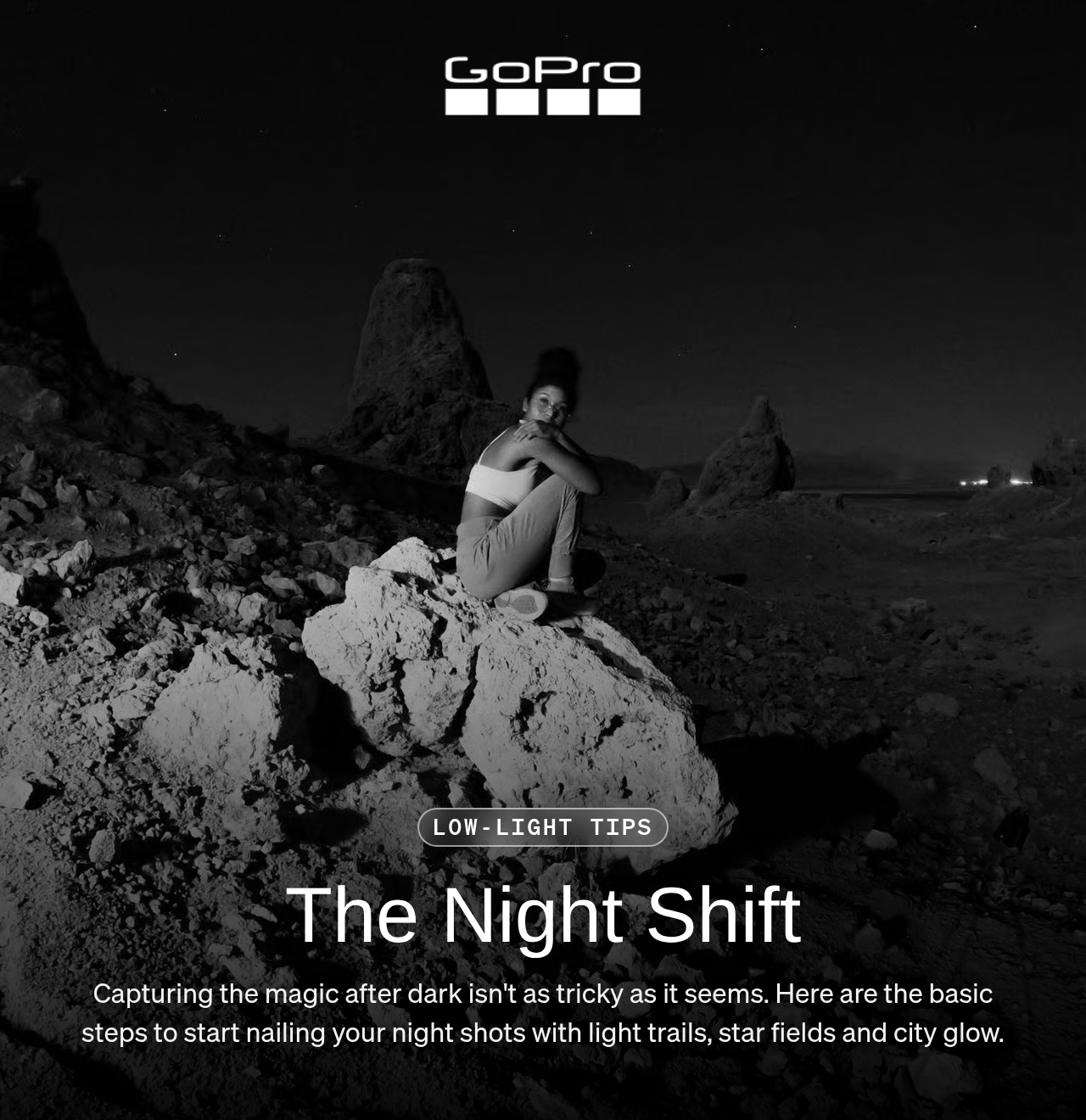 A person crouching on a rock under a night sky in the Eastern Sierras.