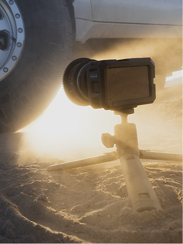 GoPro camera on a tripod in the sand.