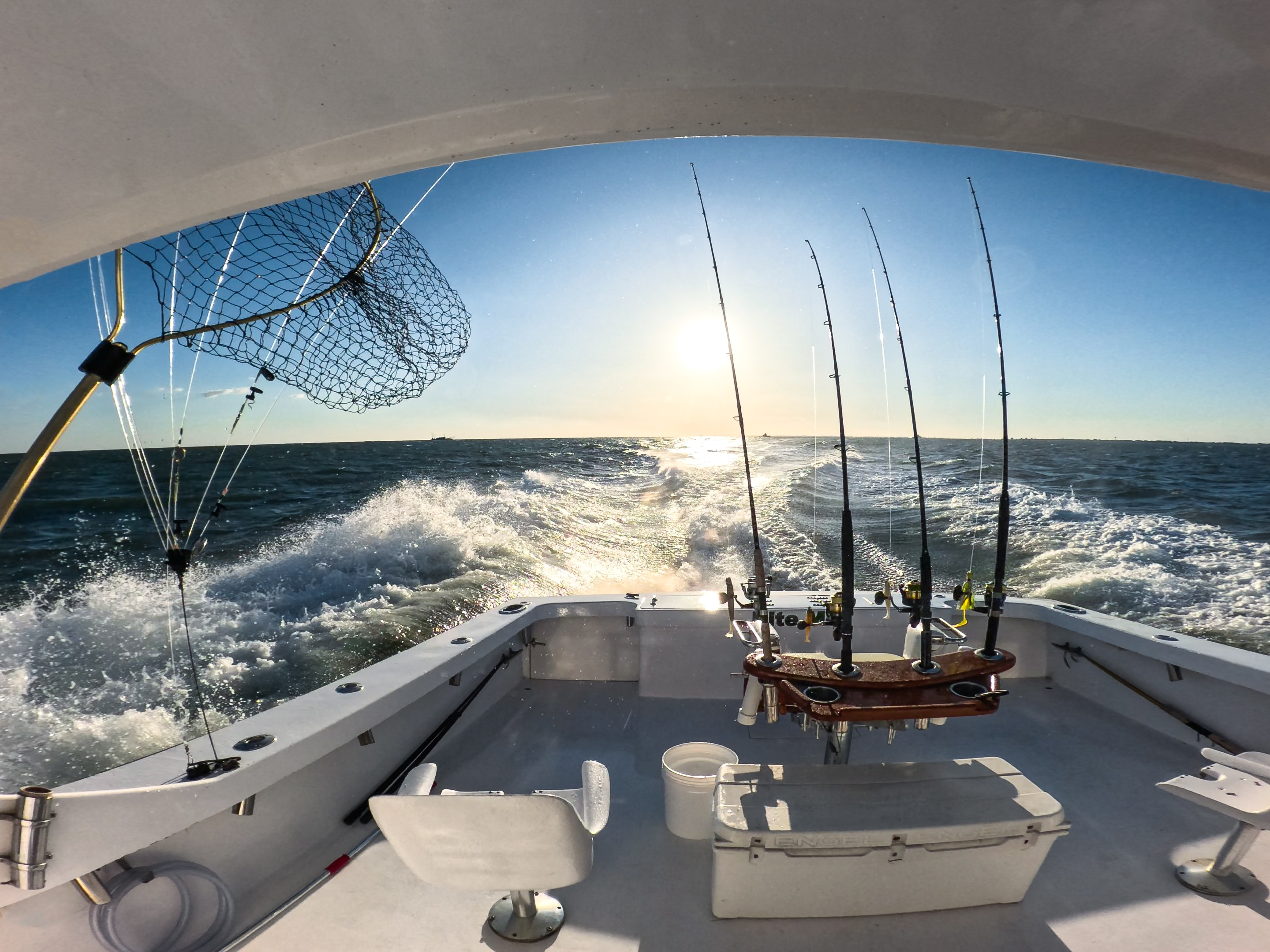 Wide-angle view of fishing boat deck at sunset.